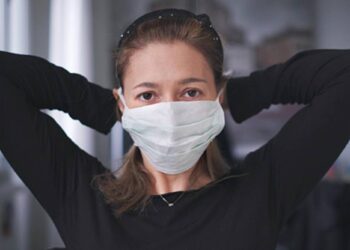 horizontal background of woman wearing surgical mask for corona virus isolation .