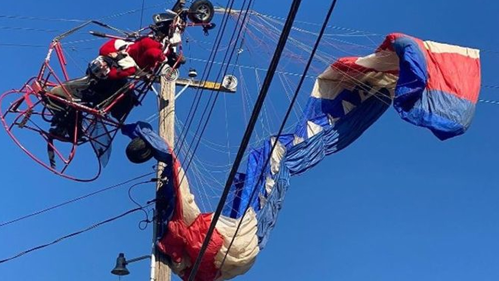 Came to give presents for Christmas;  Santa Claus crashes into a parachute and is trapped in a power line