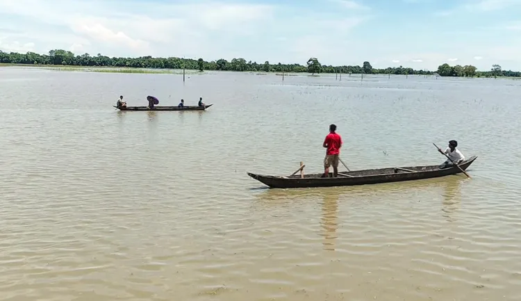 Majuli [Assam], Jul 14 (ANI): Locals make their way by boats through a flood-affected area as the water level of the Subansiri River rises due to the opening of NHPC Dam gates near the Majuli-Lakhimpur border, in Majuli on Tuesday. (ANI Video Grab)